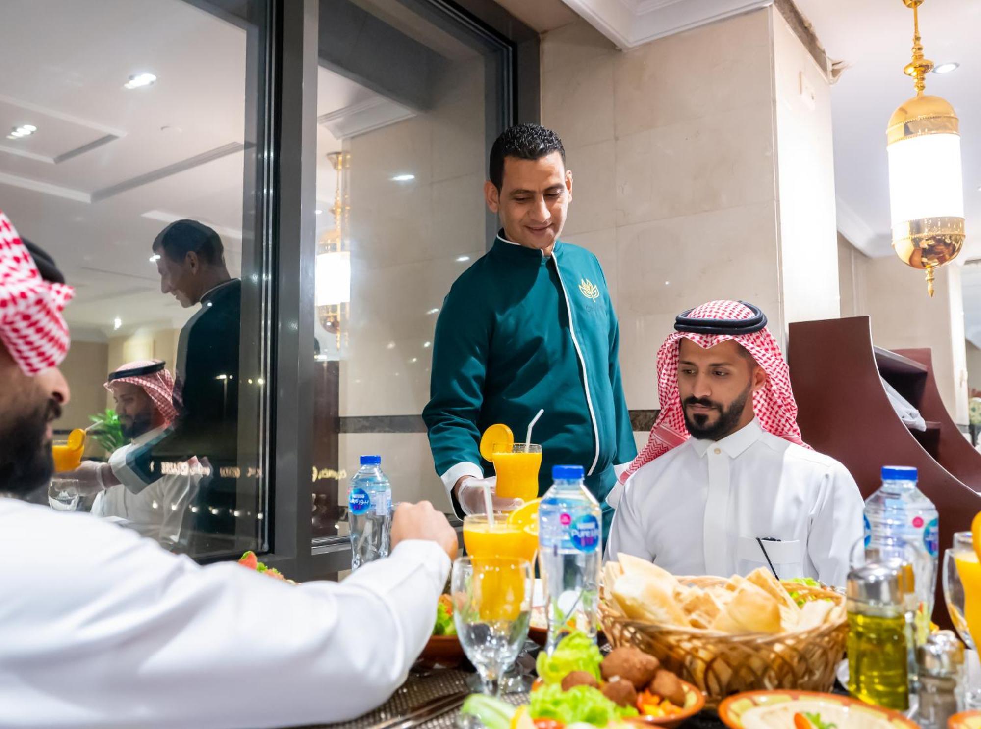 Shaza Regency Plaza Al Madinah Hotel Medina Buitenkant foto A waiter serving guests at a restaurant in Riyadh, Saudi Arabia